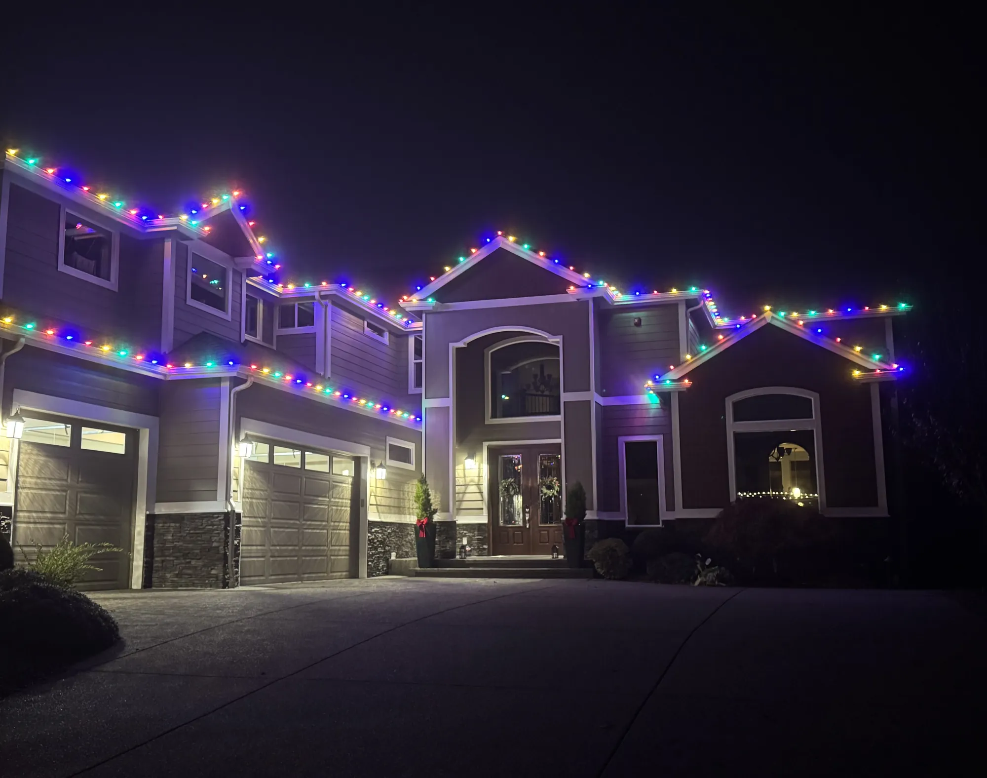 Front entry with lit garland and wreath
